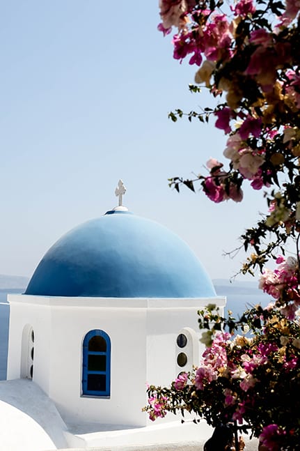 Pretty church in Santorini with pink florals for a lavish destination wedding