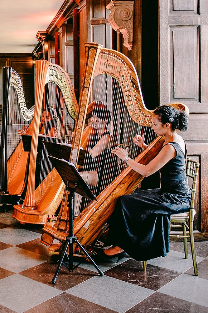 Three women playing the harp at a wedding