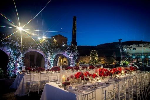 Luxury outdoor evening wedding at a luxury venue in Greece full or red roses and crystal vases