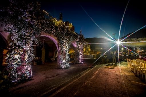Stunning flowers across three archways outside in a courtyard at a destination wedding