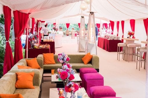 Beautifully decorated marquee with pops of red, orange and pink colours at a lush Indian wedding