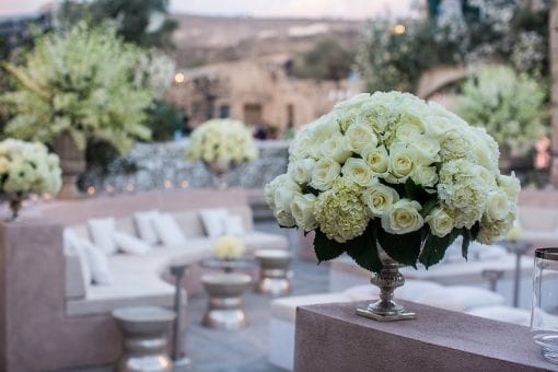 Large white floral arrangements at an outdoor luxury destination wedding in Greece