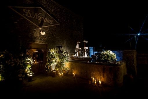 Luxury destination wedding entrance lit up with stunning floral baskets and candles