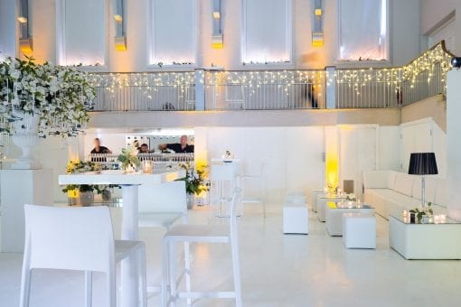 White minimalist interior design with floral bouquet centrepiece at a lavish wedding reception in London