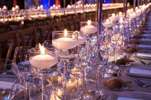 Rows of candles on long table set for wedding reception for a high end destination wedding