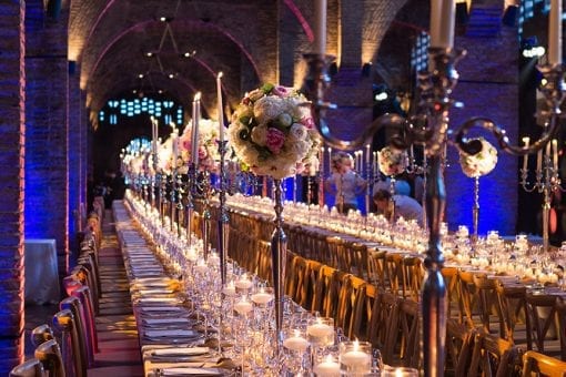 Impactful tablescape with two long banqueting tables set in a wine cellar for a luxury destination wedding in Barcelona, Spain
