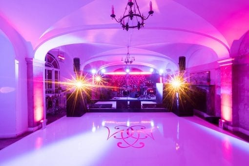 A bespoke white gloss dance floor with monogram, ready for wedding afterparty in the water terrace cafe at Blenheim Palace