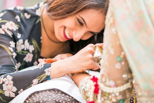 Professional henna tattoo artist applying henna to the Indian bride at a luxury Indian wedding