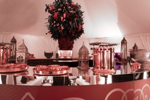 Stunning Raj tent with a round mirrored bar with decorative floral tree in the centre on the water terrace inside Blenheim Palace