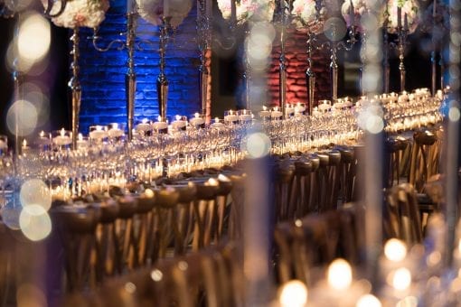 Long tables set for a luxury destination wedding in a wine cellar in Barcelona, Spain