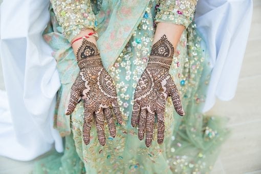 Luxury Indian wedding with the bride at the Mehndi with her hands decorated with beautiful henna art