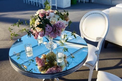 Roses and pink flowers in an intricate glass vase on a mirrored poseur table at high end wedding venue Blenheim Palace
