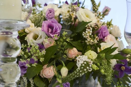 Large glass candle holders with elegant and luxury wedding flowers