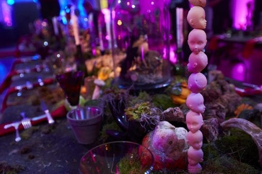Miniature doll heads stacked on top of each other on a dinner party table for a quirky styled private event in London