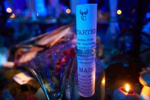 Edible menus rolled up inside a glass bottle