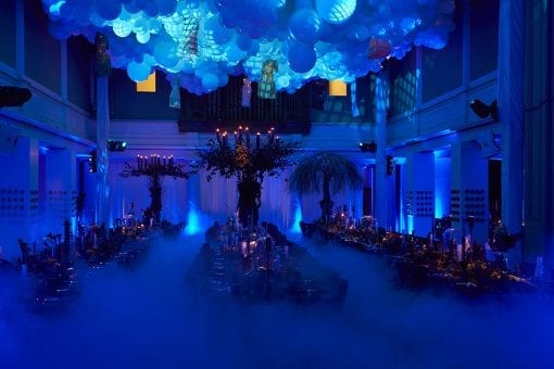 A balloon cloud lit up over a haze covered dining room beautifully lit ready for a private party at One Marylebone
