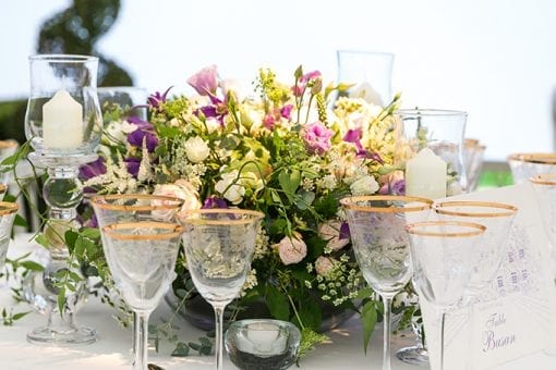 Beautiful tablescape with a pink and cream colour palette, flowers, candles and gold rimmed glassware