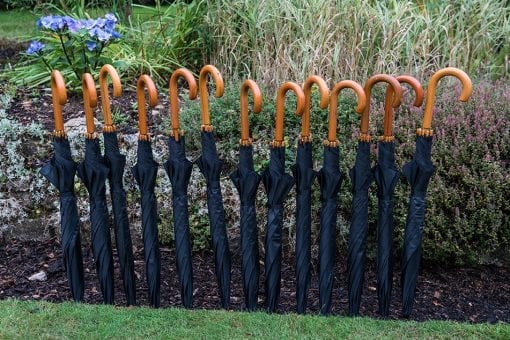 Fun umbrellas staked in the landscaped garden of a private wedding estate
