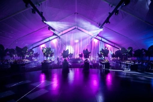 A purple and pink lighting design at Battersea Power Station under a glass marquee for an event