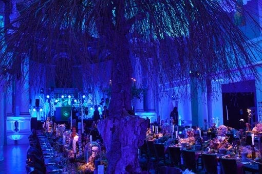 A stunning world class produced party with long wooden tables, balloon ceiling arrangements and trees for a private birthday party in London