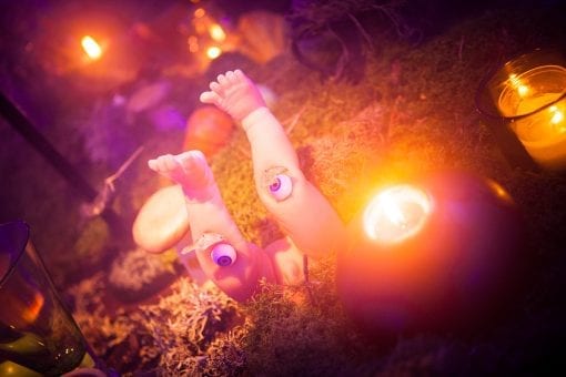 Decorative baby doll legs with eyeballs in the knees on a table at a surrealist themed party