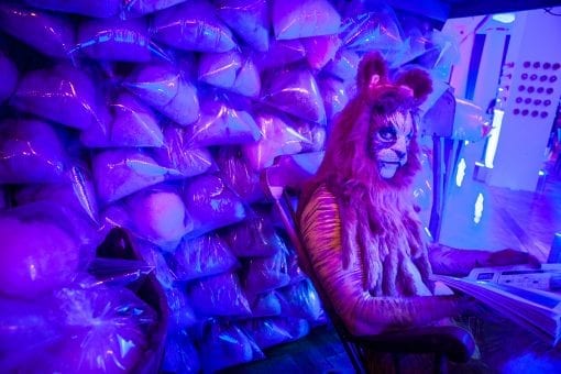 Best roving performers and artists at a Surrealist Party reading Tatler next to a wonderful candy store