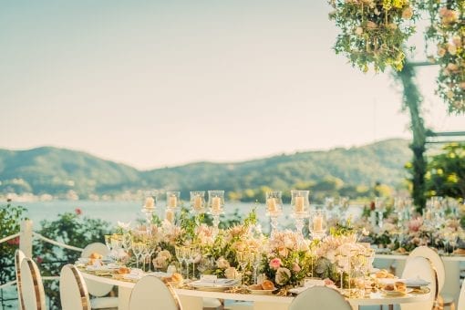 Beautiful table with long floral centrepiece and candles overlooking luxury wedding destination, Lake Como