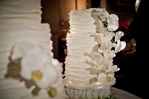 Luxurious white wedding cake decorated with white orchids at the Victoria and Albert Museum in London