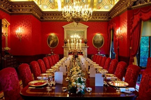 The William Kent Room at the Ritz in London with table set up with gold charger plates and crystal glassware