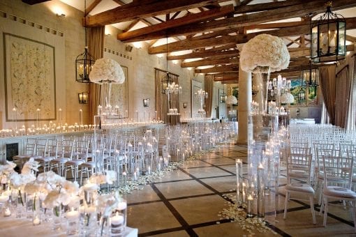 Enchanting wedding aisle filled with candles, rose petals and white orchids and hydrangeas