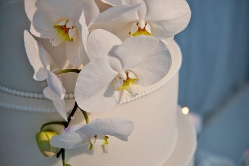 Luxurious five tiered white wedding cake decorated with beautiful white orchids