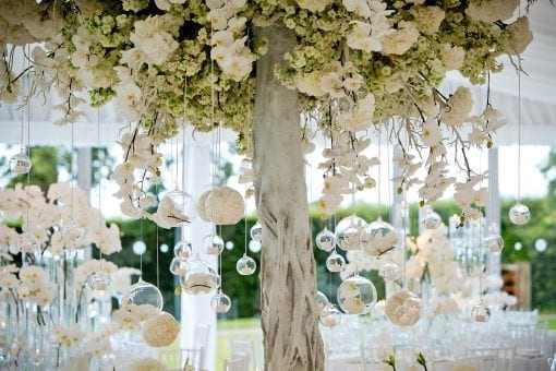Decorative white tree styled with white flowers in hanging glass baubles