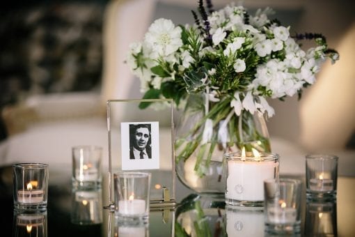 Delicate garden flowers on a mirror top table with candles at a private event at a private estate