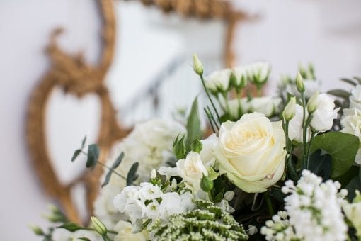 Cream and green flowers next to a gold mirror at One Marylebone
