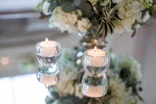 Pretty candles on mirror top tables at a luxury private event