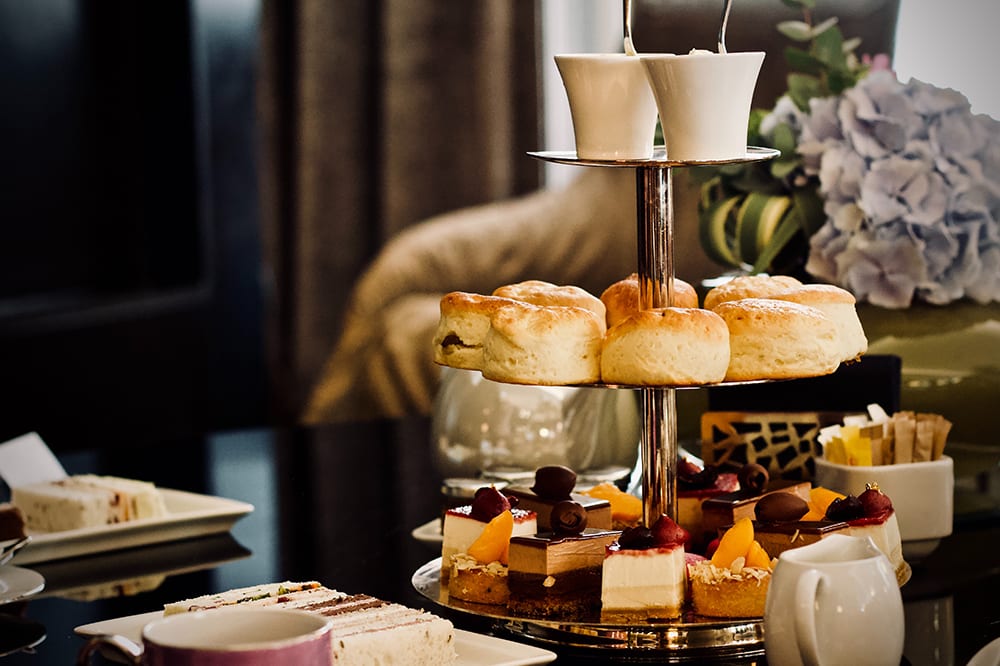 Afternoon tea with scones, fruit cakes and tea at luxury wedding venue Claridges Hotel in London