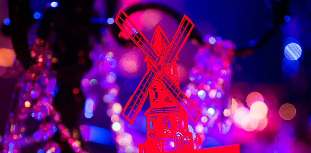 Stationery details of laser cut table numbers of a windmill styled menu cards for a Moulin Rouge themed birthday party in London.