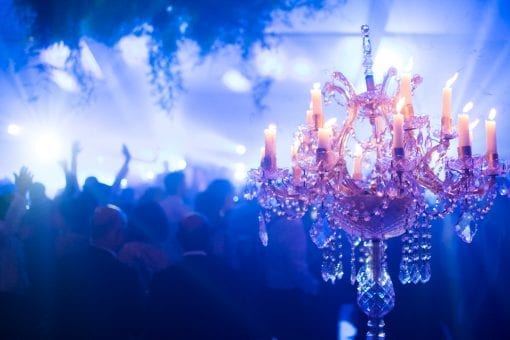 Crystal candelabra with lit candles as table centre piece at luxury wedding reception