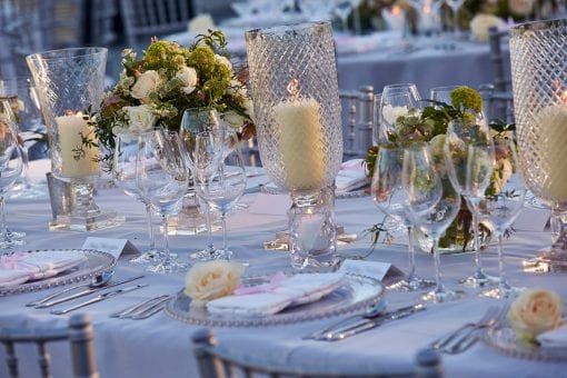 Stunning crystal table settings with pillar candles, rose buds and beautiful florals at Blenheim Palace.