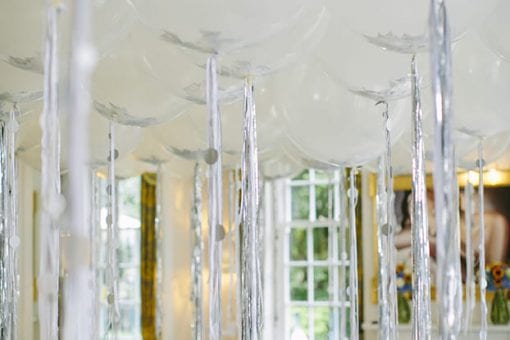An entire ceiling covered with white and silver balloons for a private birthday party