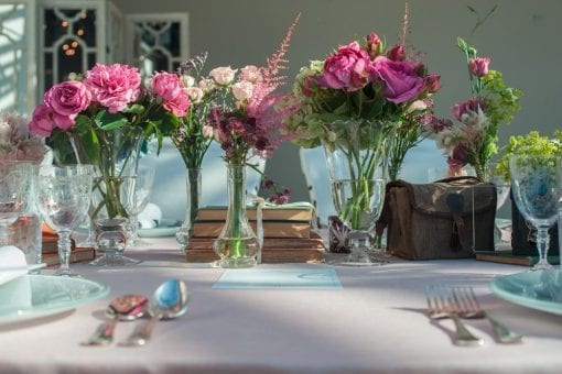 A vintage styled lunch with themed props and individual floral vases in the South of France