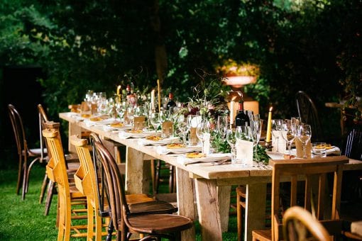 Beautifully styled Countryside wedding with wooden tables in a garden set for dinner