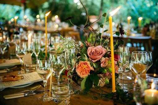 Candle lit dinner table decorated with English Countryside flowers for a wedding