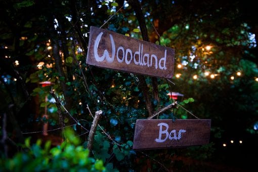 Woodland bar signs at a rustic styled wedding in the English Countryside