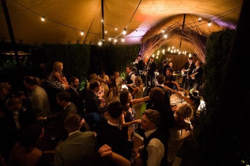 Luxury wedding afterparty dancing under a festoon lit stretch tent