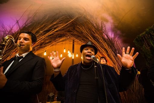 Top in demand band performing at a luxury countryside wedding under a stretch tent and bespoke built rustic arch and festoon lighting