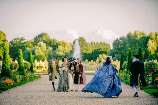 Guests at a luxury birthday party in period costume arriving in the Privy Garden at Hampton Court Palace
