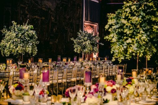 The most stunning tablescape with green trees and purple and cream colour scheme in the Great Hall at Hampton Court Palace