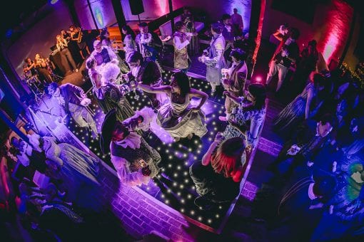 Guests in period costume on a black pin spot dance floor at luxury birthday party