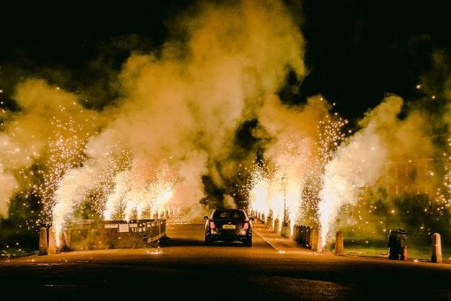 Ground fireworks lighting the exit as a Bentley Mulsanne drives away from Hampton Court Palace